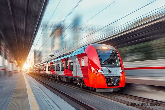 Electric passenger train drives at high speed among urban landsc Ein Zug fährt durch eine urbane Landschaft